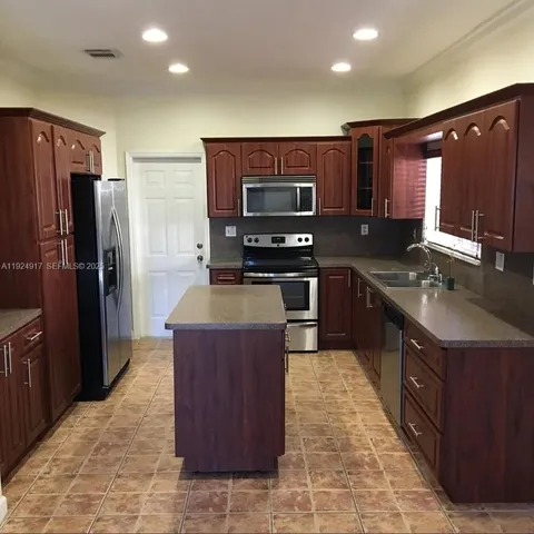 a kitchen with stainless steel appliances granite countertop a stove a sink dishwasher a refrigerator and a oven