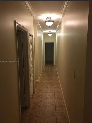 an empty room with a chandelier fan and a large window