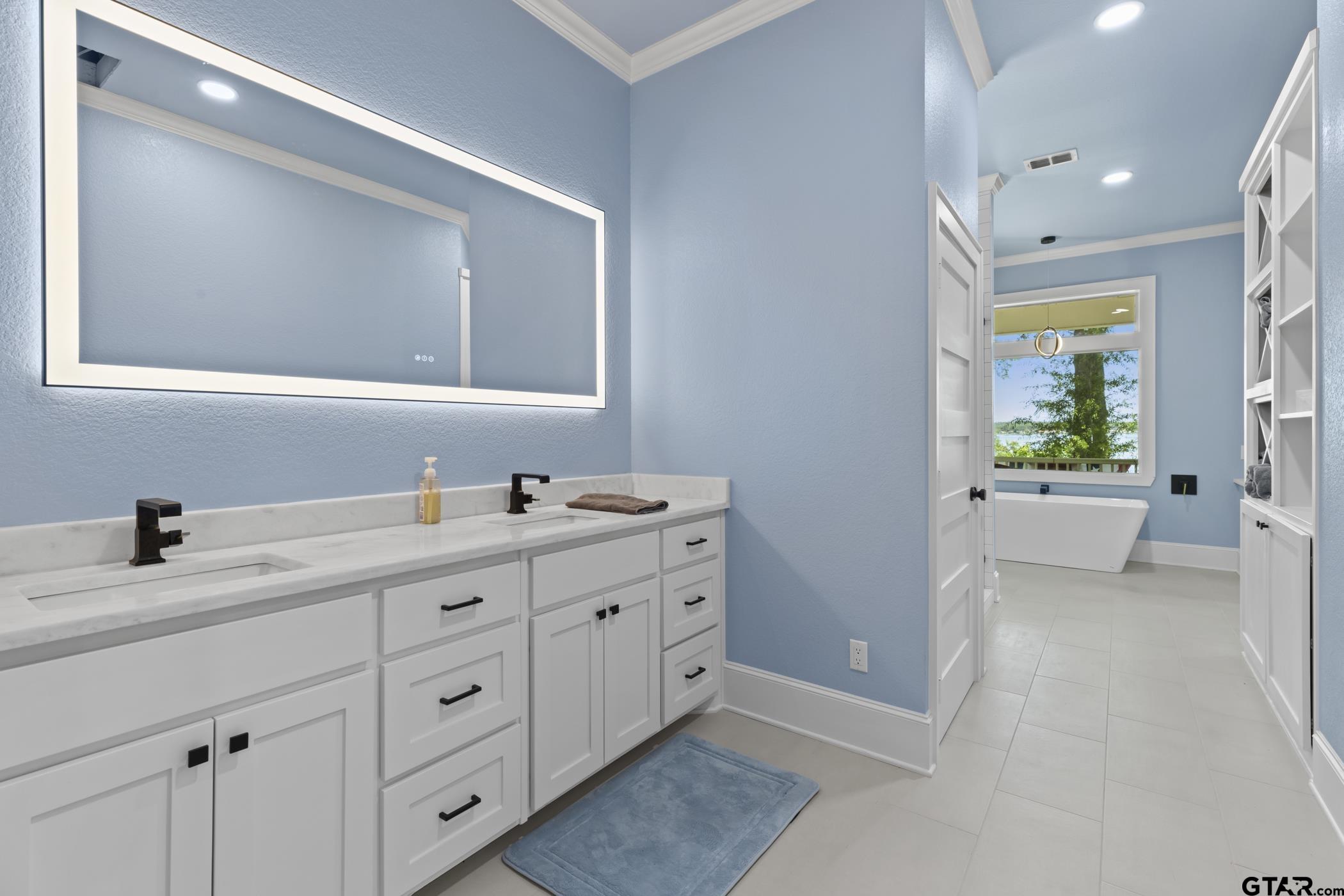 18630 Eastside Road Troup, TX 75789 - Photo 27 of 47 a bathroom with a double vanity sink a mirror and next to a window