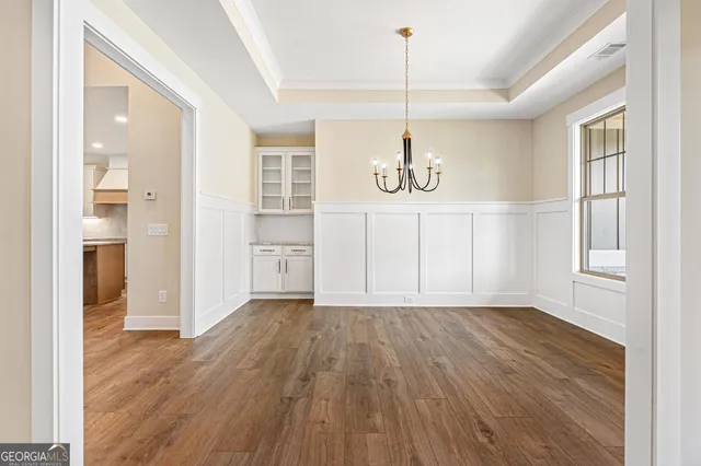 an empty room with wooden floor fireplace and windows