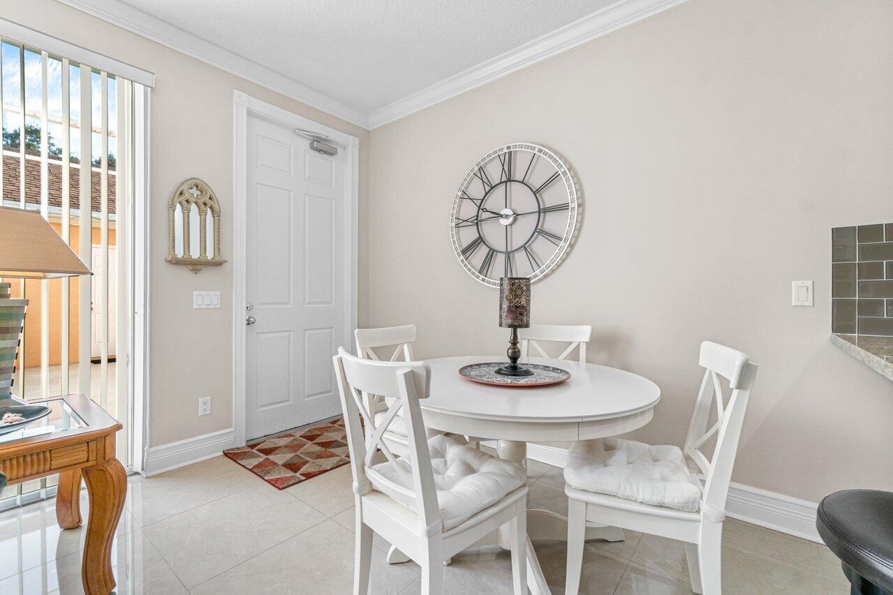 107 Andover Drive Jupiter, FL 33458 - Photo 11 of 26 a view of a dining room with furniture a chandelier and wooden floor