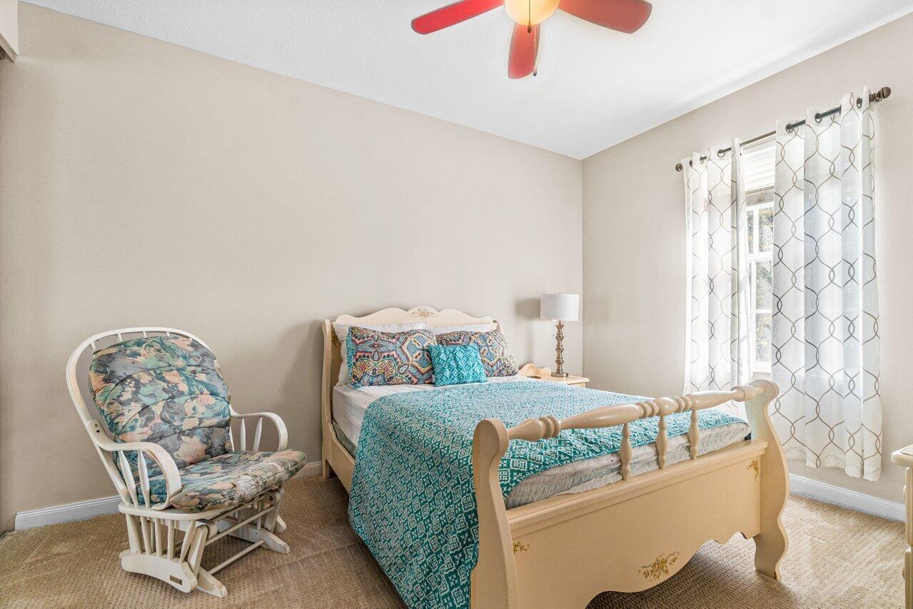 107 Andover Drive Jupiter, FL 33458 - Photo 15 of 26 a bedroom with a bed and a chair