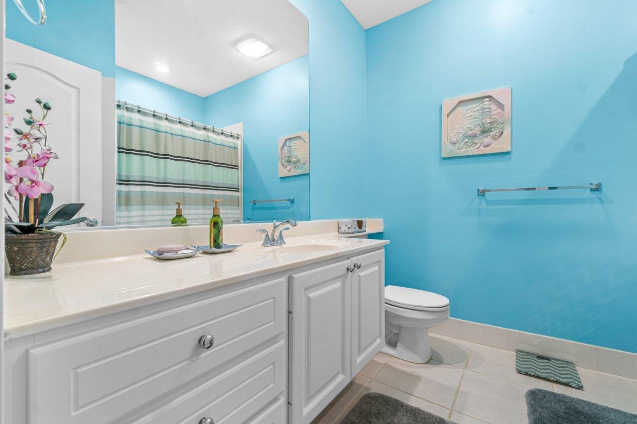 107 Andover Drive Jupiter, FL 33458 - Photo 17 of 26 a bathroom with a sink mirror vanity and toilet
