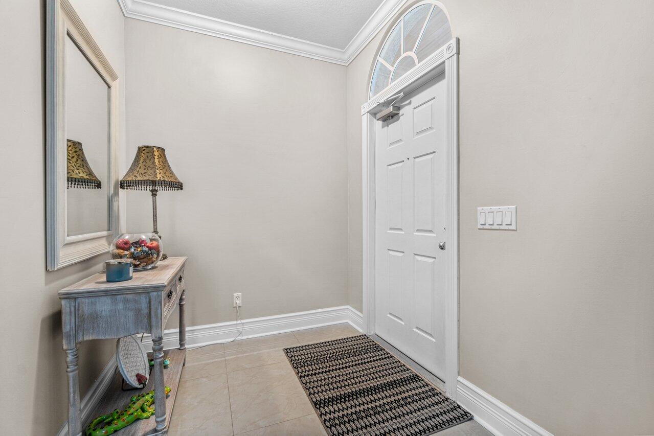 107 Andover Drive Jupiter, FL 33458 - Photo 5 of 26 a hallway with a potted plant on th wall