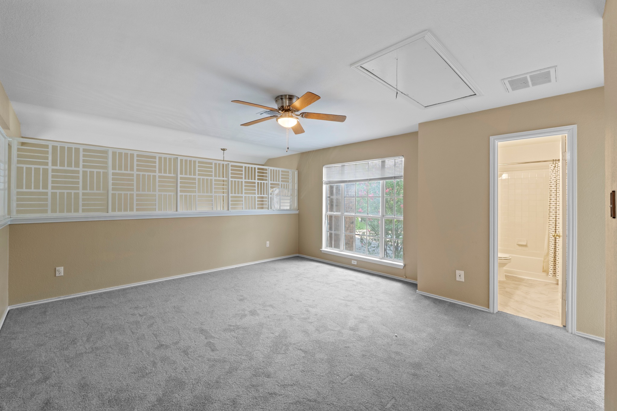 8605 Axis Drive Austin, TX 78749 - Photo 24 of 38 A versatile bonus room features a patterned half-wall, soft gray carpet, and a ceiling fan for comfort.