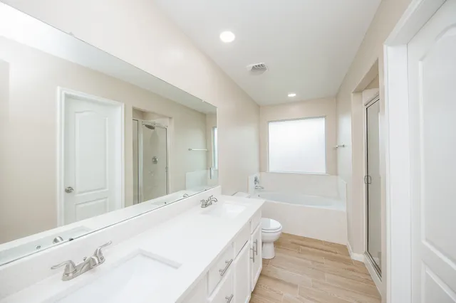 a bathroom with a bathtub a sink and a large mirror