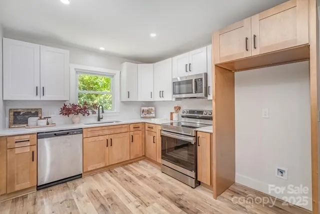 a kitchen with stainless steel appliances granite countertop a stove a sink and a refrigerator