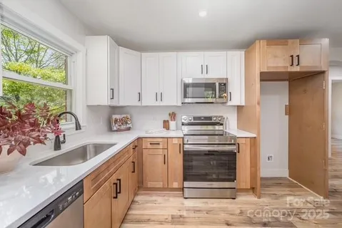 a kitchen with stainless steel appliances granite countertop a sink stove and refrigerator