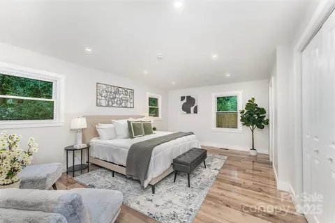 a spacious bedroom with a bed a couch and potted plant