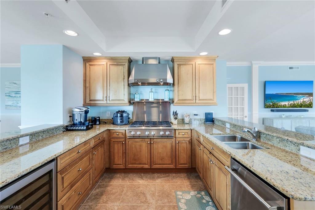 275 Indies Way, Unit 706 Naples, FL 34110 - Photo 12 of 50 a kitchen with a sink a counter top space cabinets and stainless steel appliances