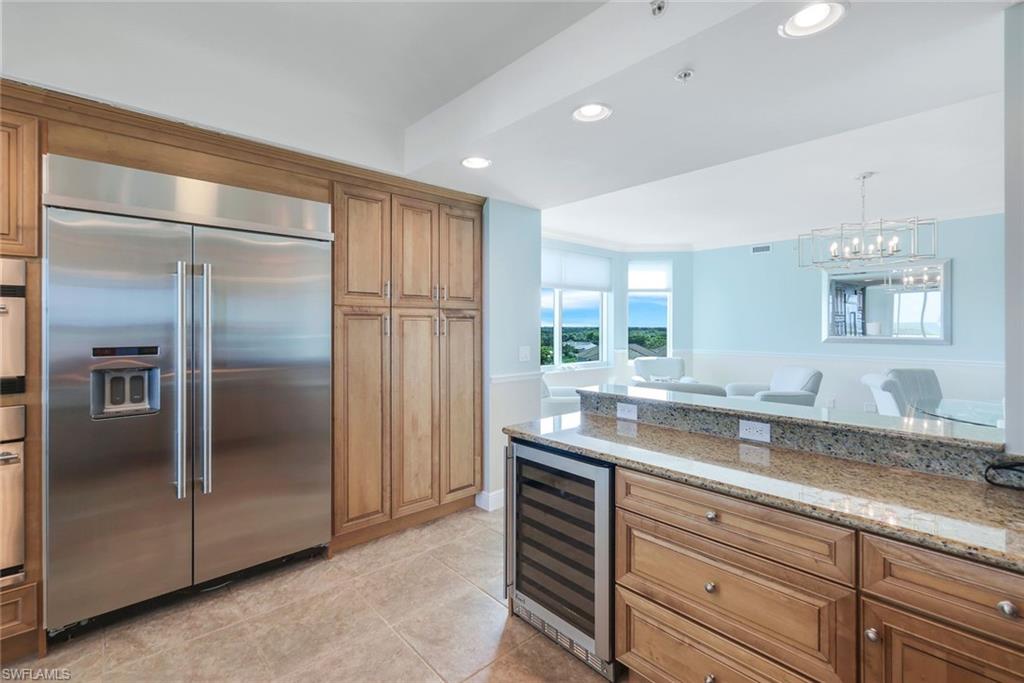 275 Indies Way, Unit 706 Naples, FL 34110 - Photo 14 of 50 a kitchen with a refrigerator and countertop double vanity sink