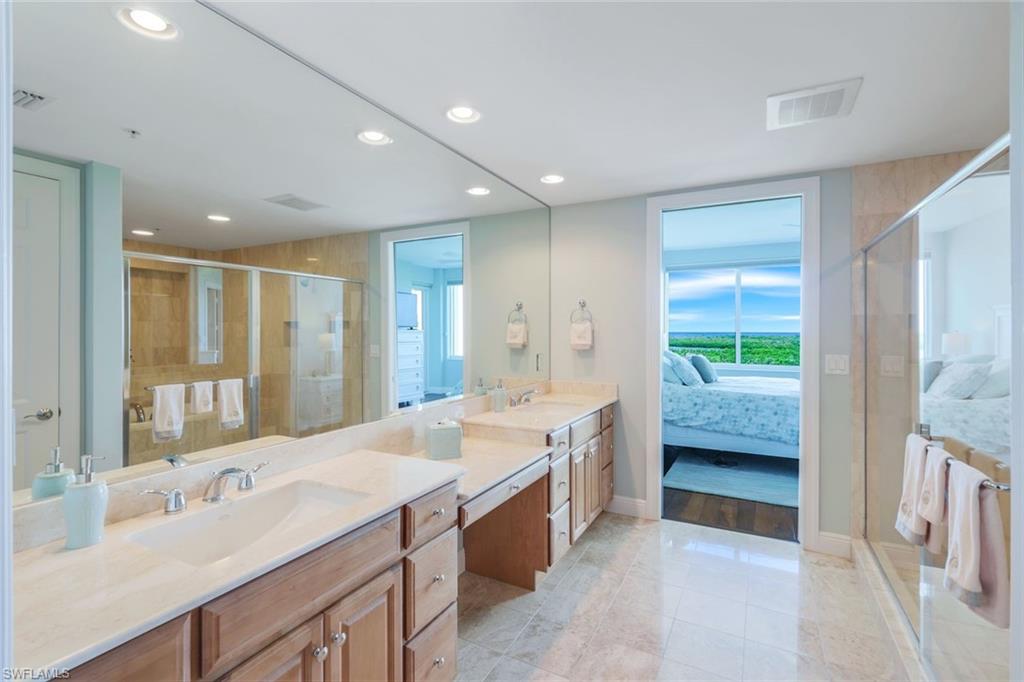 275 Indies Way, Unit 706 Naples, FL 34110 - Photo 20 of 50 a large bathroom with a double vanity sink and a large mirror