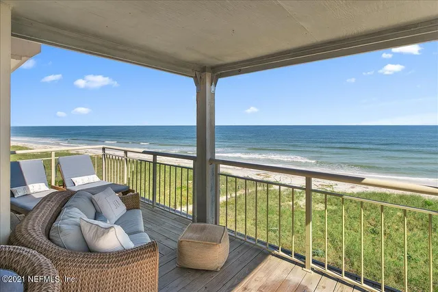 a balcony with chairs and wooden floor
