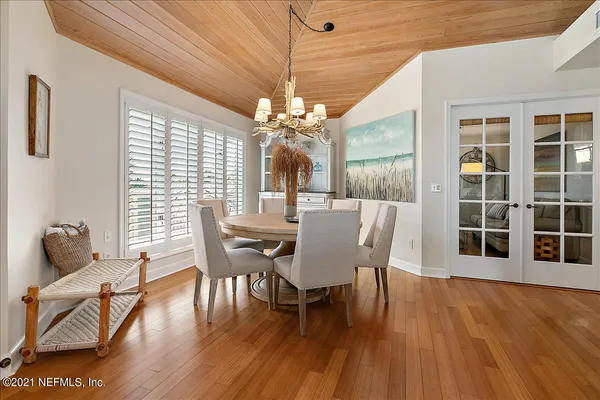a view of a dining room with furniture a chandelier and wooden floor