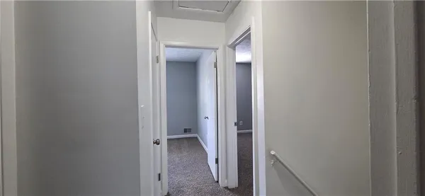 a view of a hallway with a refrigerator and a sink
