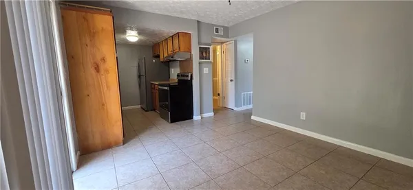 a view of a hallway with closet and a bathroom