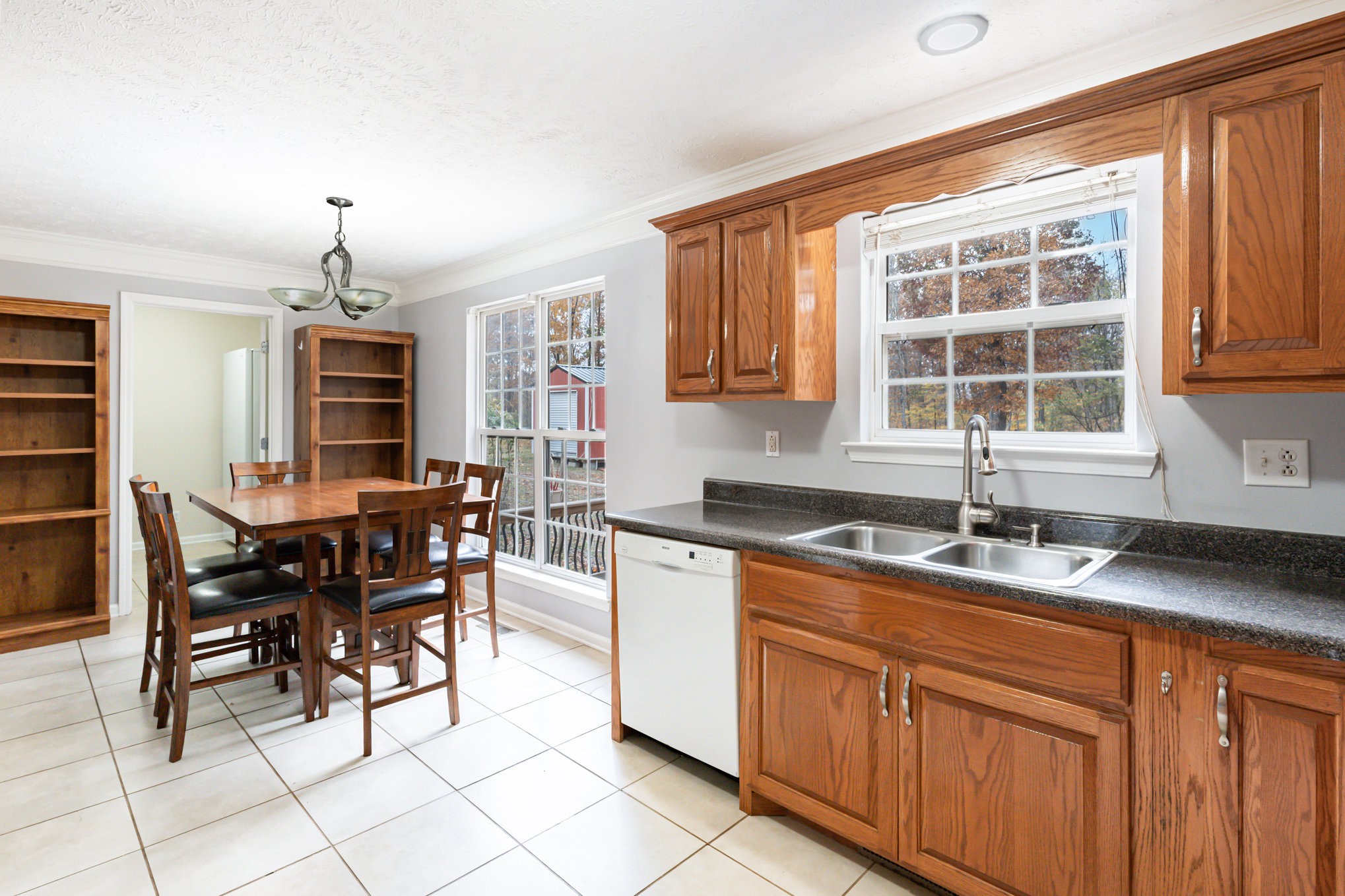 3075 Bowker Road Charlotte, TN 37036 - Photo 9 of 28 a kitchen with granite countertop wooden cabinets dining table and chairs