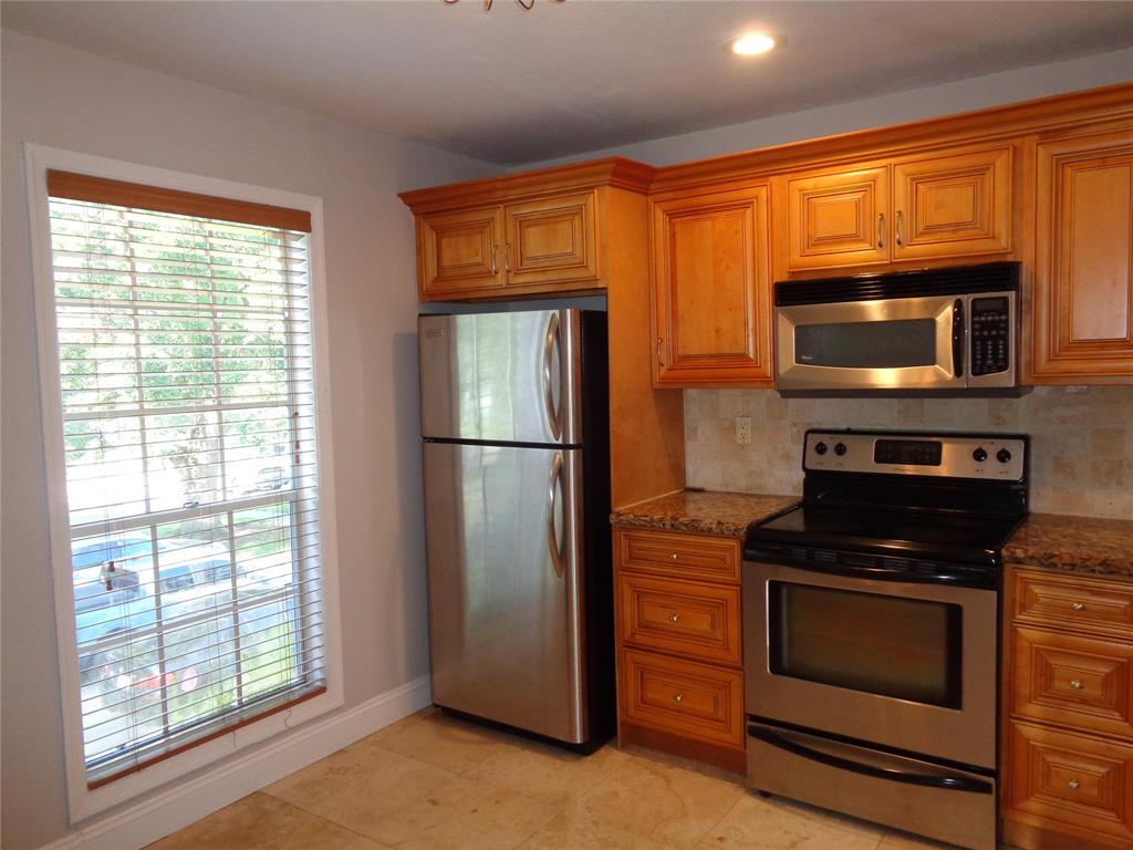 5048 Heatherhill Lane, Unit 1204 Boca Raton, FL 33486 - Photo 8 of 31 a kitchen with granite countertop wooden cabinets and stainless steel appliances