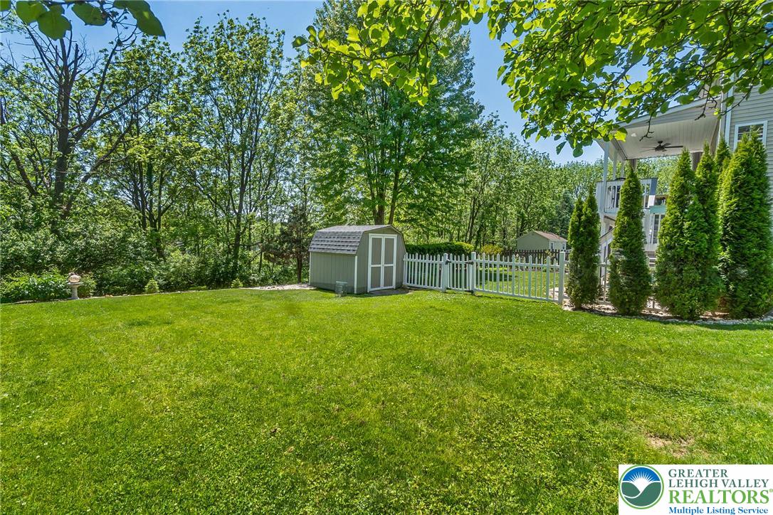 2314 Red Maple Drive Coplay, PA 18037 - Photo 69 of 73 A verdant backyard offers a spacious lawn, white picket fence, and secluded storage shed.
