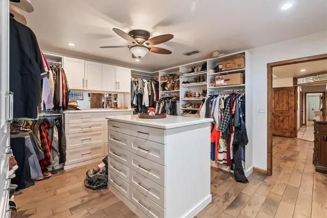 a view of walk in closet with clothes and shoes