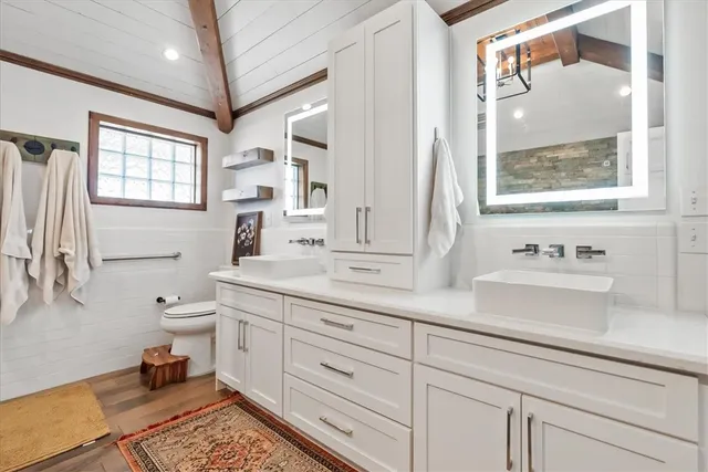 a bathroom with a toilet a sink and mirror