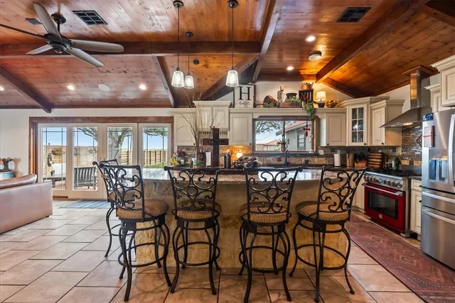 a room with stainless steel appliances lots of wooden furniture