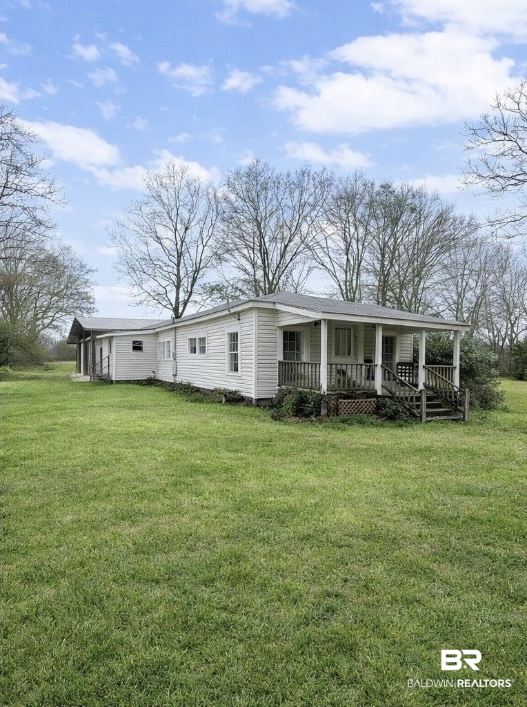 604 Pitman Platt Road Fruitdale, AL 36539 - Photo 1 of 1 Rear view of property featuring covered porch and a yard. Image is digitally edited