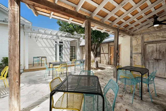 a view of a patio with table and chairs and potted plants