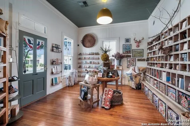 a living room with lots of wooden furniture and a large window