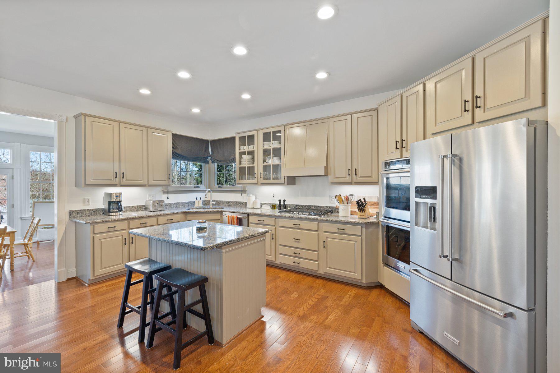 20623 Cutwater Place Sterling, VA 20165 - Photo 19 of 59 a kitchen with stainless steel appliances granite countertop a refrigerator a sink dishwasher a stove and white cabinets with wooden floor