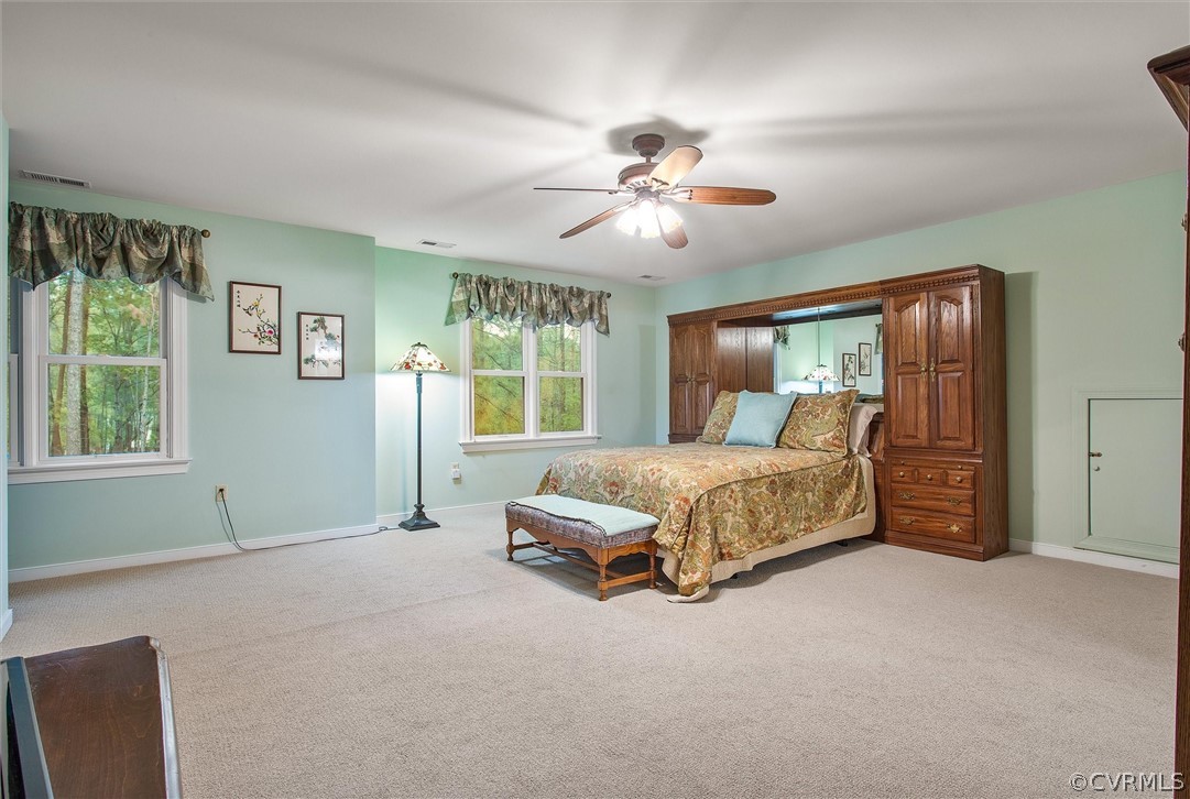 2763 Checketts Drive Sandy Hook, VA 23153 - Photo 26 of 36 a spacious bedroom with a large bed and a chandelier