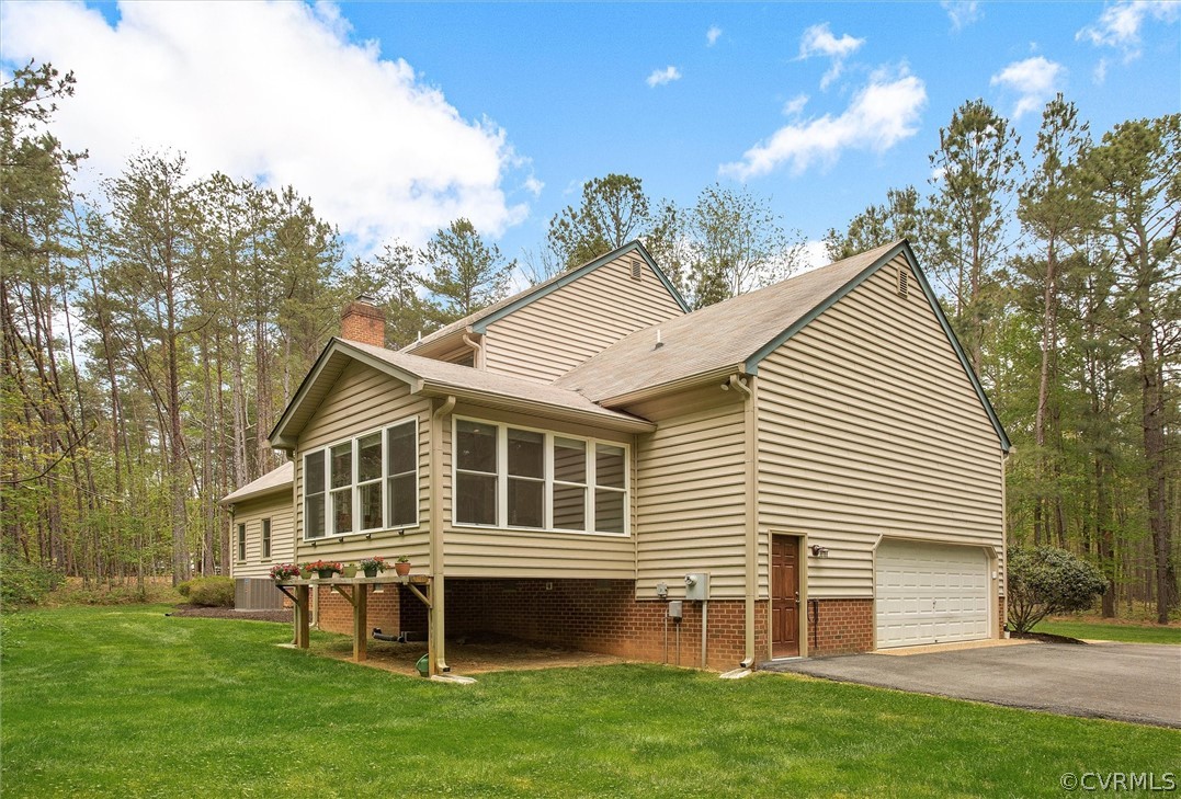 2763 Checketts Drive Sandy Hook, VA 23153 - Photo 36 of 36 a view of a white house with a large window and a yard