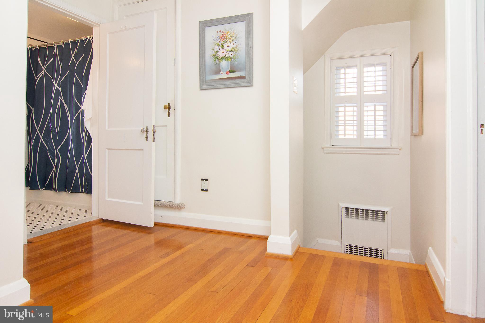 636 Overbrook Road Baltimore, MD 21212 - Photo 19 of 38 a view of an empty room with wooden floor and a window