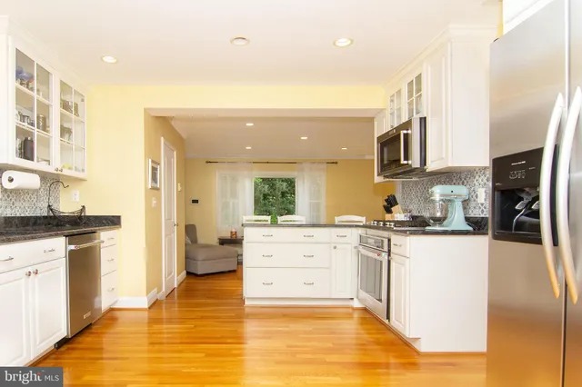 a large kitchen with stainless steel appliances granite countertop a stove and a sink