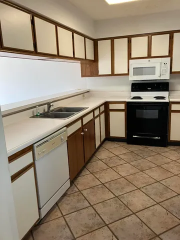 a kitchen with granite countertop a stove sink and cabinets