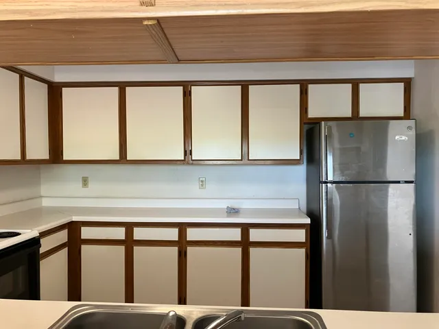 a kitchen with a window and a refrigerator
