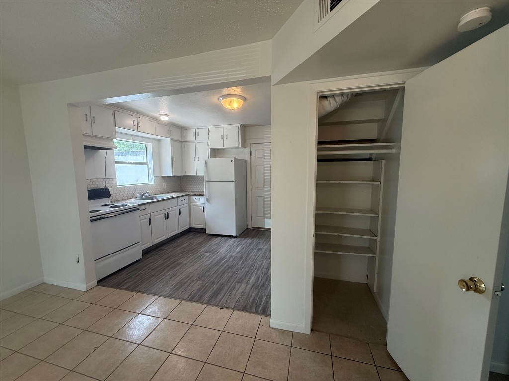 622 Trinity Street Lockhart, TX 78644 - Photo 4 of 16 a kitchen with a refrigerator and white cabinets