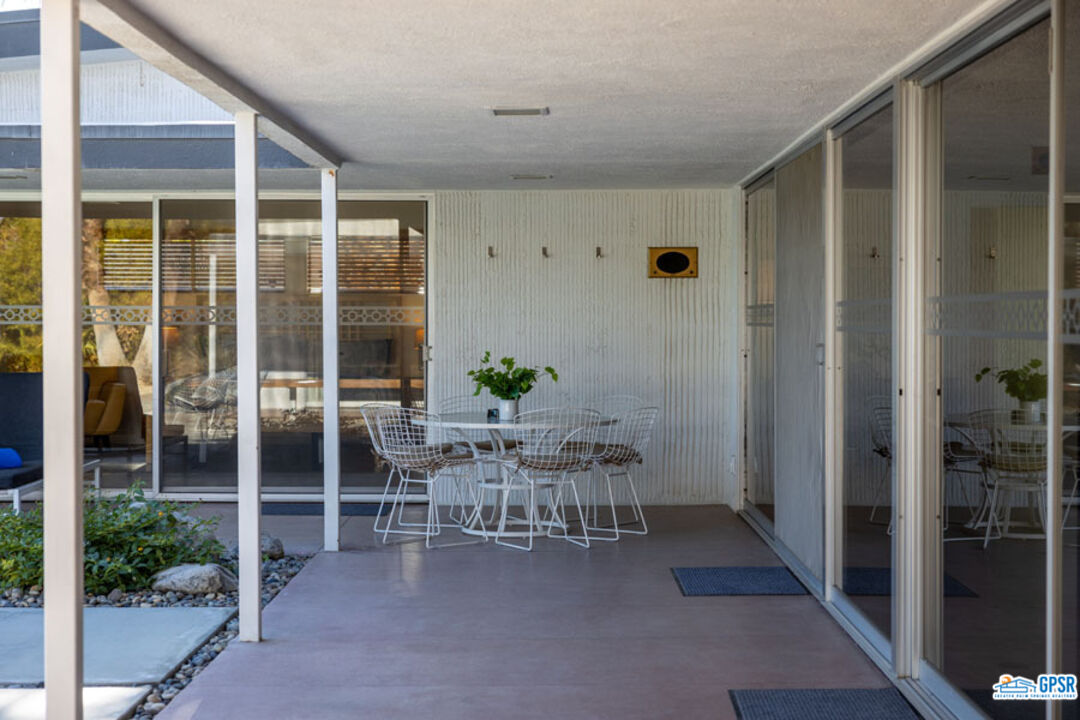 1090 Sagebrush Road Palm Springs, CA 92264 - Photo 16 of 49 a view of a porch with dining table and chairs