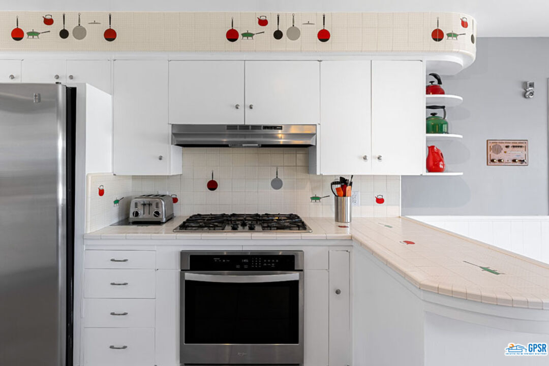 1090 Sagebrush Road Palm Springs, CA 92264 - Photo 24 of 49 a kitchen with a stove and white cabinets