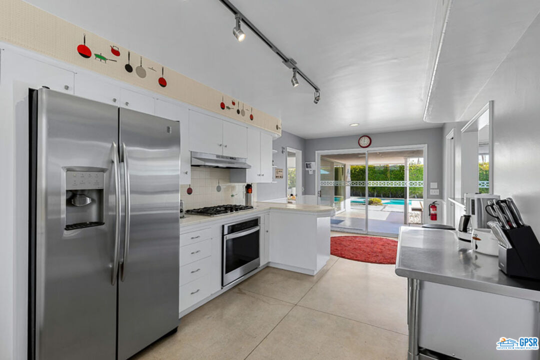 1090 Sagebrush Road Palm Springs, CA 92264 - Photo 25 of 49 a kitchen with granite countertop a sink stainless steel appliances and cabinets