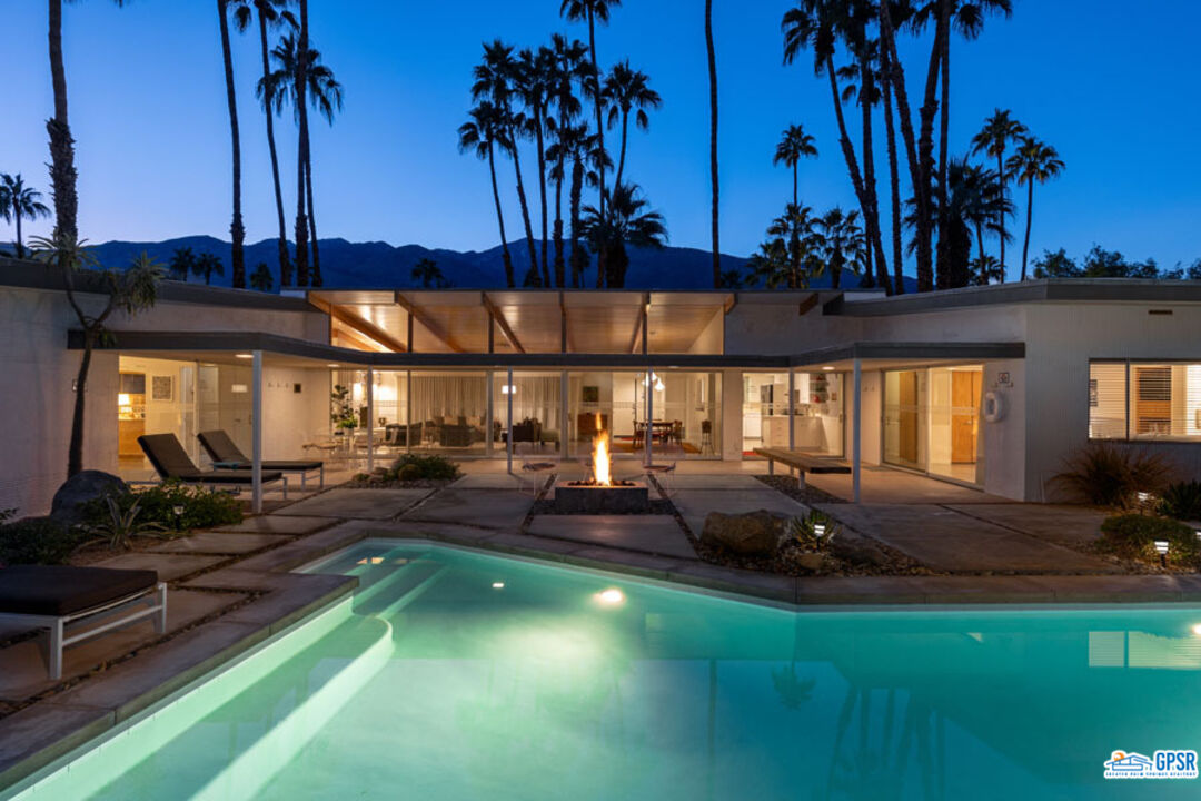 1090 Sagebrush Road Palm Springs, CA 92264 - Photo 44 of 49 a view of a swimming pool with lawn chairs under an umbrella
