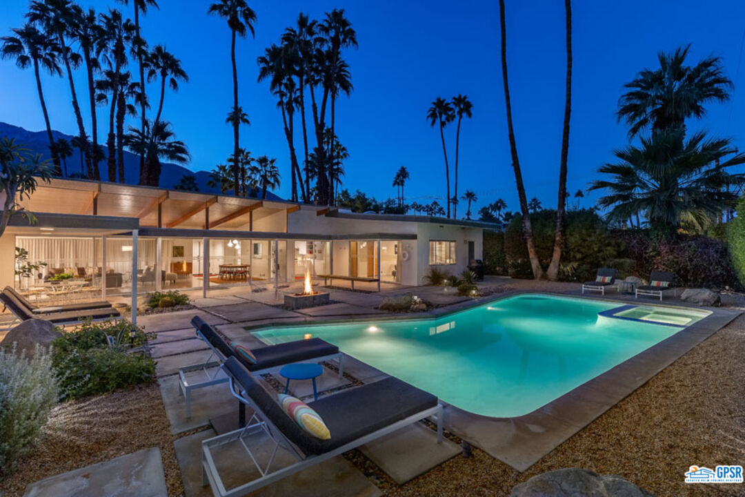 1090 Sagebrush Road Palm Springs, CA 92264 - Photo 47 of 49 a view of a swimming pool with lawn chairs under an umbrella