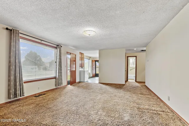 a view of a big room with windows and chandelier fan