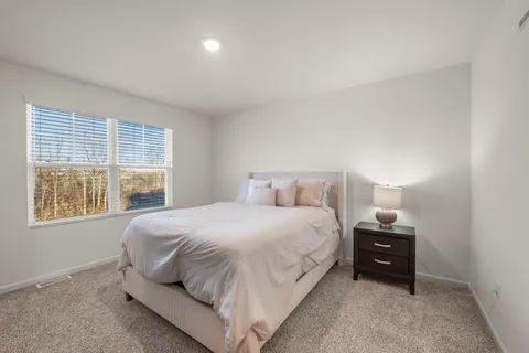 a bedroom with a bed and a night stand