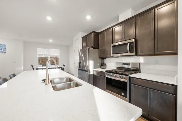 a kitchen with stainless steel appliances granite countertop a sink dishwasher stove and refrigerator