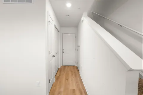 a view of a hallway with closet and wooden door
