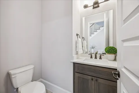 a bathroom with a sink toilet and a mirror