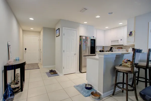 a kitchen with refrigerator and chairs