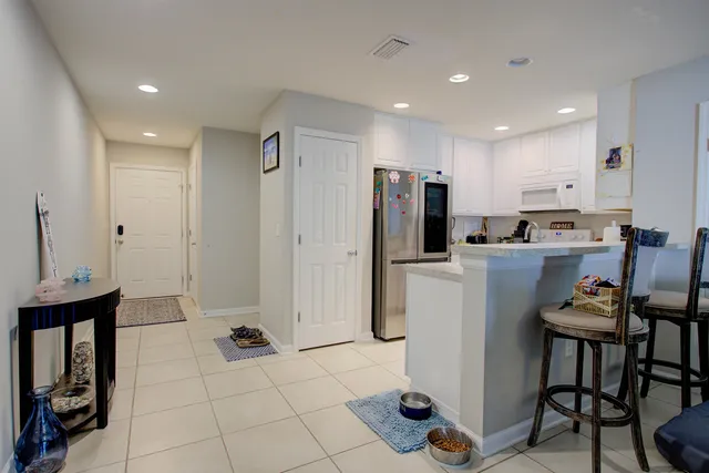 a kitchen with refrigerator and chairs
