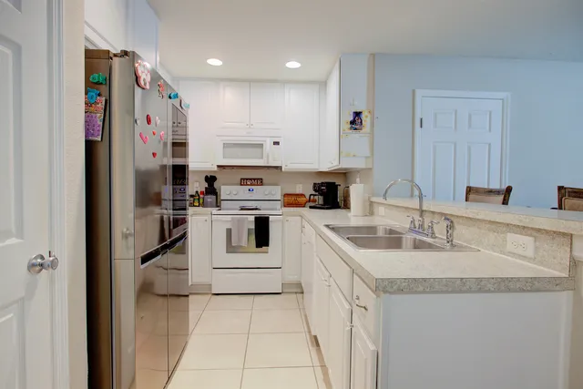a kitchen with white cabinets and refrigerator